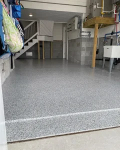 Clean garage interior with gray speckled flooring and organized storage.