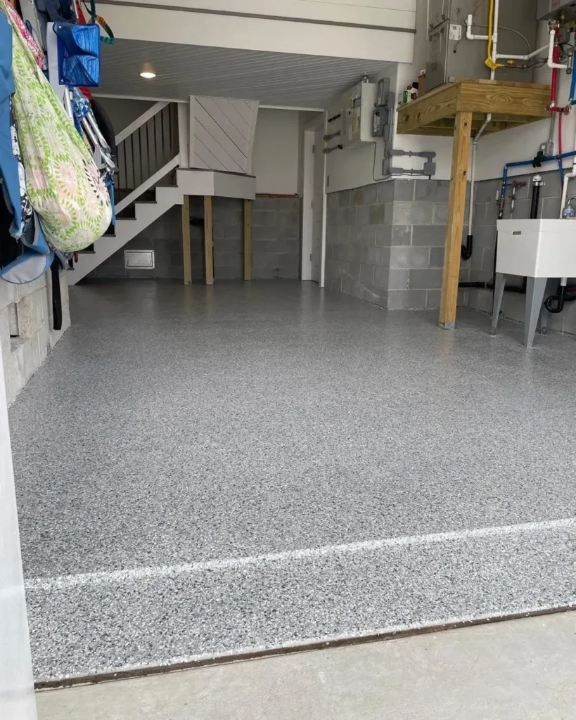 Clean garage interior with gray speckled flooring and organized storage.