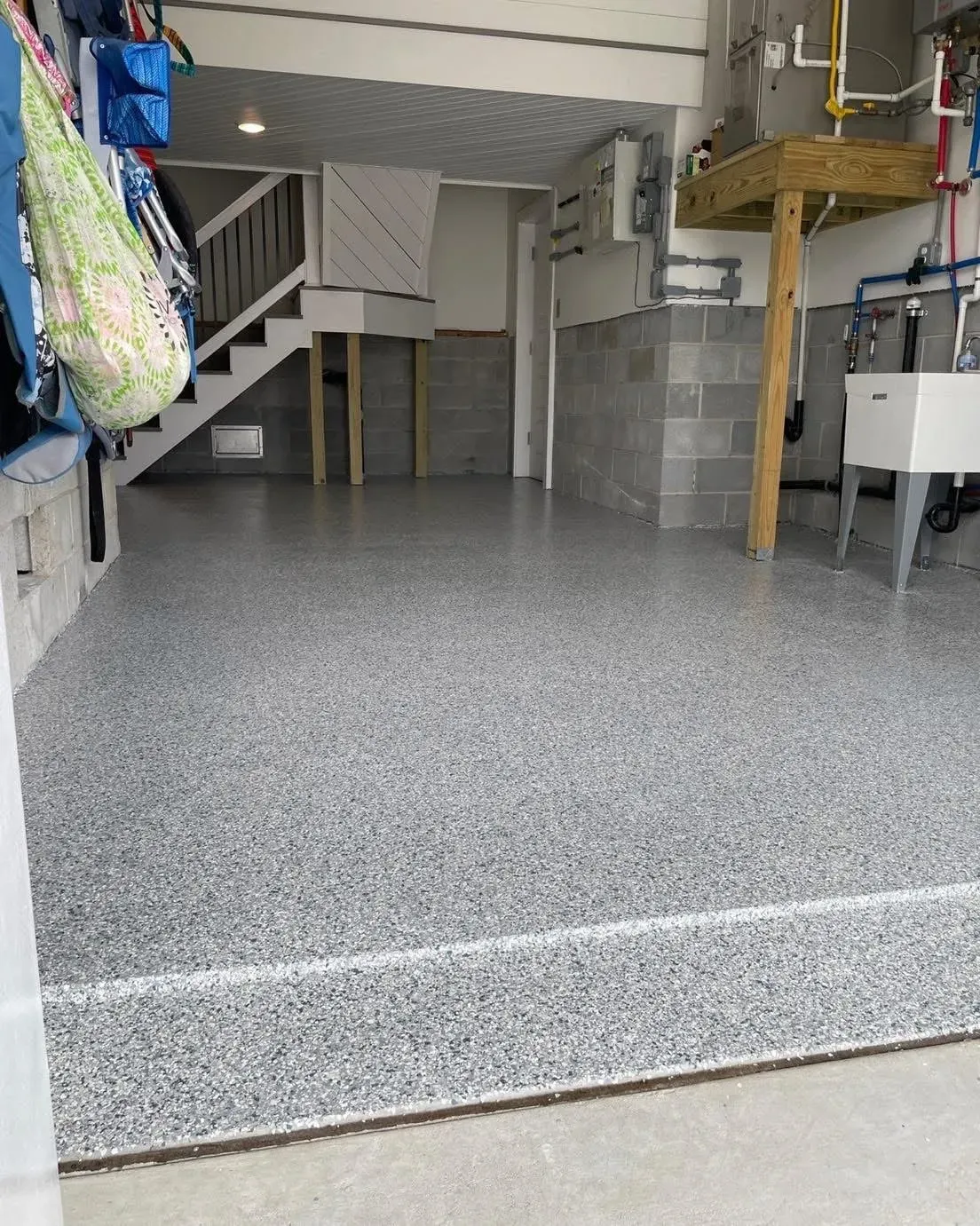 Clean garage interior with gray speckled flooring and organized storage.